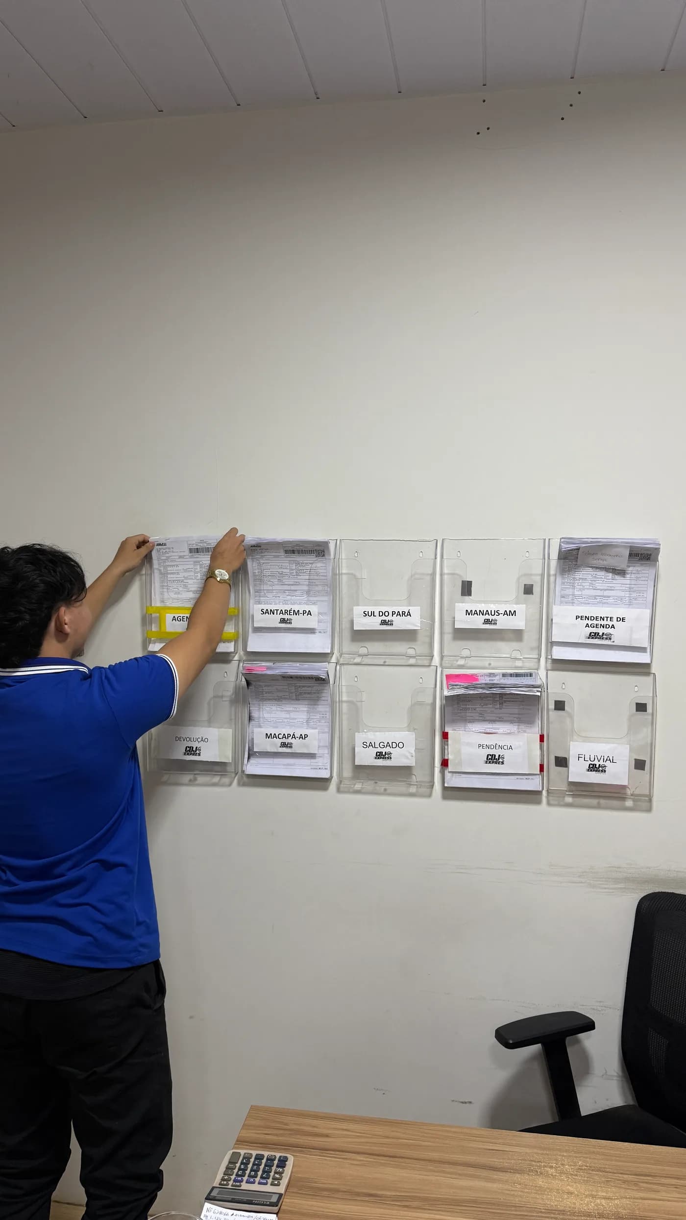 Profissional da CDJ Express organizando documentos de remessas por rota