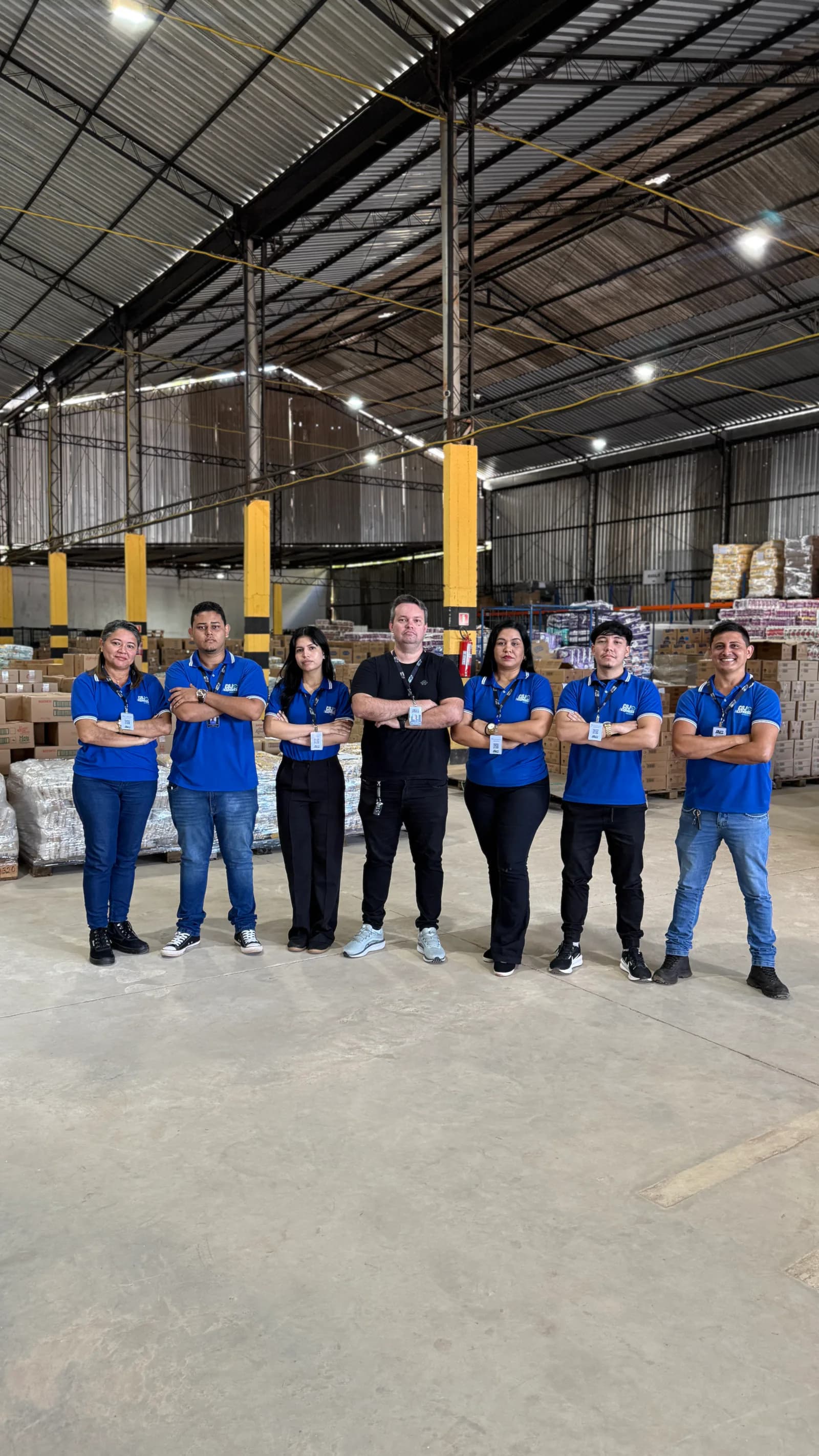 Equipe da CDJ Express posicionada diante de cargas no galpão