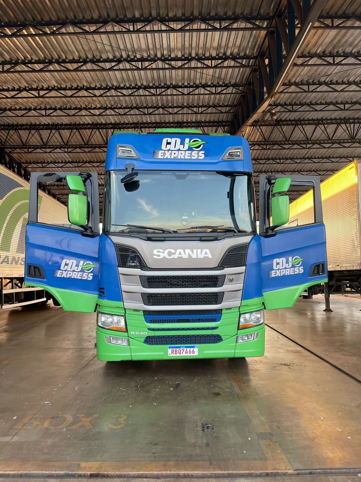 Caminhão azul e verde da CDJ Express preparado na base operacional